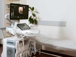 Ultrasound machine setup in a clinic room, ready for patient examination.